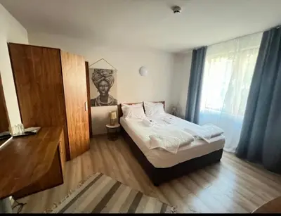 a bedroom with a bed and a desk and a window at Къща за гости Беглик таш 3 in Primorsko