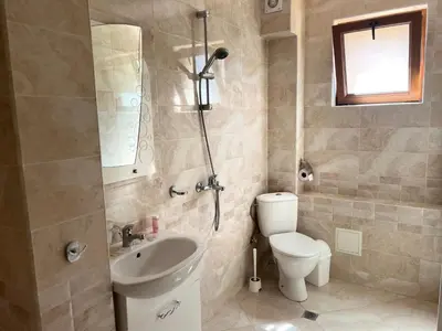 a bathroom with a toilet and a sink and a shower at Къща за гости Беглик таш 3 in Primorsko