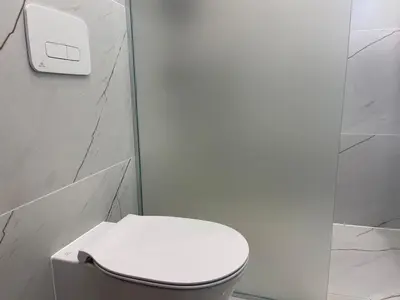 a bathroom with a white toilet and a white wall at Luxury Sea nest next Marina Dinevi in Sveti Vlas