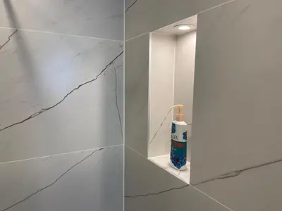 a bathroom with white marble walls and a soap dispenser at Luxury Sea nest next Marina Dinevi in Sveti Vlas