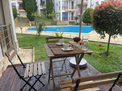 a table and chairs on a patio with a pool at Luxury Sea nest next Marina Dinevi in Sveti Vlas