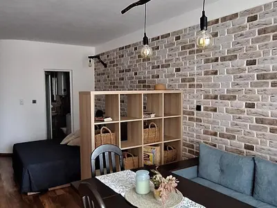 a living room with a brick wall at Студио Бяла in Byala