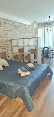 a large bed in a room with a brick wall at Студио Бяла in Byala