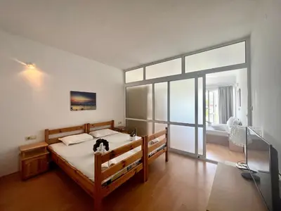 a bedroom with a bed with a cat sitting on it at Апартамент Съни Хаус - Sunny House Apartment in Byala