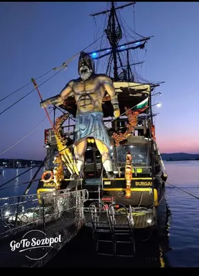 a statue of a man sitting on the back of a boat at Sozopol Sunrise in Sozopol