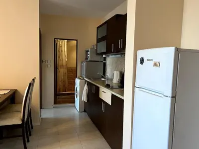 a kitchen with a white refrigerator and a table at Sea Side Apartment with Balcony in Sveti Vlas