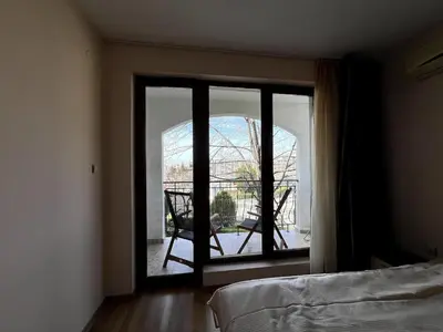 a room with a window with a chair and a balcony at Sea Side Apartment with Balcony in Sveti Vlas
