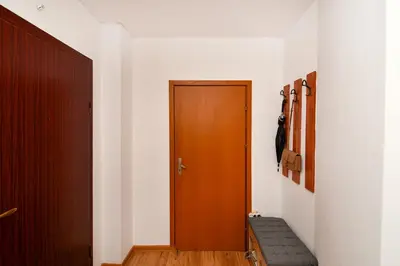 a hallway with a wooden door and a bench at Roman Thermae, steps from the sea with free parking in Varna City