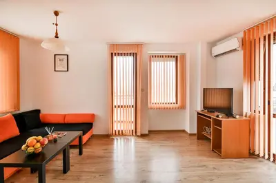 a living room with a couch and a tv at Roman Thermae, steps from the sea with free parking in Varna City