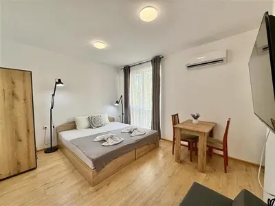 a bedroom with a bed and a table in it at Menada Aphrodite Green Apartments in Sunny Beach