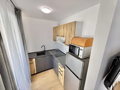 a small kitchen with a refrigerator and a microwave at Menada Aphrodite Green Apartments in Sunny Beach