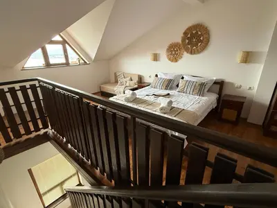 a bedroom with a bed and a staircase at Cosy Seaview apartment Budjaka in Sozopol