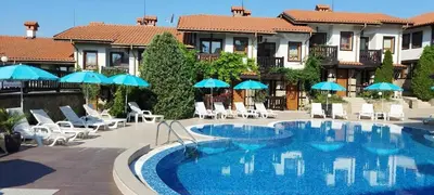 a large swimming pool with chairs and umbrellas at Cosy Seaview apartment Budjaka in Sozopol