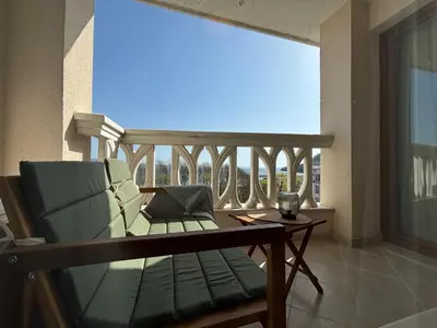 a balcony with a couch and a table and a window at Blue Horizon Suite in Varna City