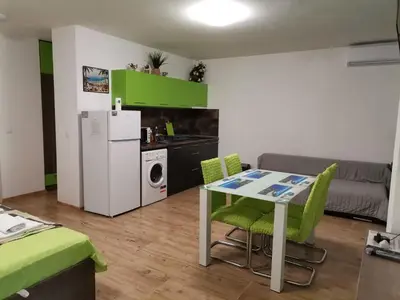a kitchen and living room with a table and a refrigerator at Path ways to the Sea -Пътека към морето in Primorsko