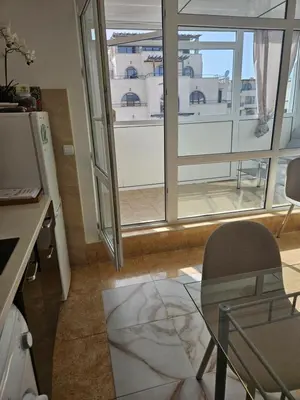 a living room with a glass table and a window at Elite 4 in Sunny Beach