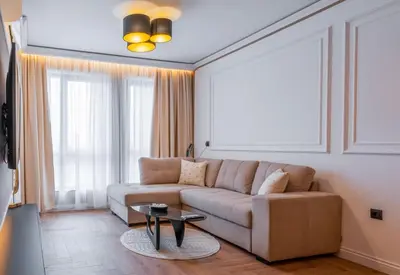 a living room with a couch and a table at ВХТИ Park - Premium Apartment in Burgas City