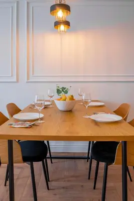 a wooden table with a bowl of fruit and wine glasses at ВХТИ Park - Premium Apartment in Burgas City