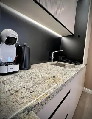 a kitchen with a counter with a mixer and a sink at ВХТИ Park - Premium Apartment in Burgas City