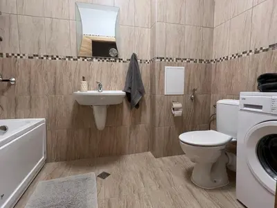 a bathroom with a toilet sink and a washing machine at Family Apartment with Sea View Vineyard Spa Resort Aheloy in Aheloy