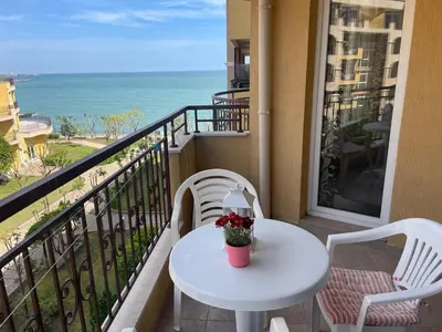 a white table and chairs on a balcony with the ocean at The Royal Bay Hideaway Studio in Aheloy