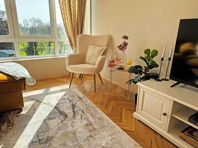 a living room with a tv and a chair and a table at AURA BEACH apartment in Burgas City