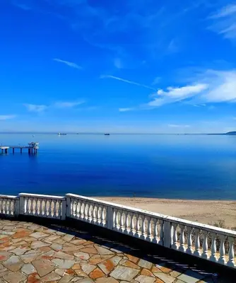 a white fence on the beach near the water at AURA BEACH apartment in Burgas City
