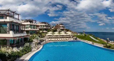 a resort with a swimming pool next to the ocean at Art Complex Anel in Sozopol