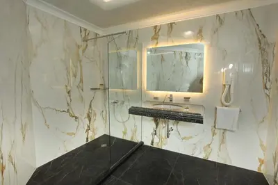 a marble bathroom with a sink and a mirror at Art Complex Anel in Sozopol