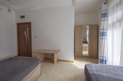 a bedroom with two beds and a table in it at Sea Garden Marina 1 Apartment Varna in Varna City