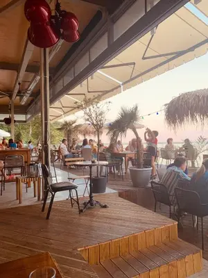 a group of people sitting at tables in a restaurant at Sea Garden Marina 1 Apartment Varna in Varna City