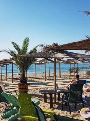 a man sitting on a beach near the ocean at Cozy Studio in Varna City