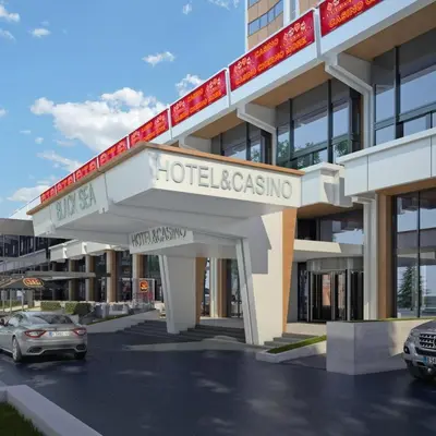 a hotel casino with cars parked in a parking lot at Cozy Studio in Varna City