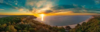 a sunset over a body of water with trees at Cozy Studio in Varna City
