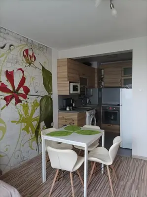 a kitchen with a white table and white chairs at Apartment Maria Luisa in Burgas City