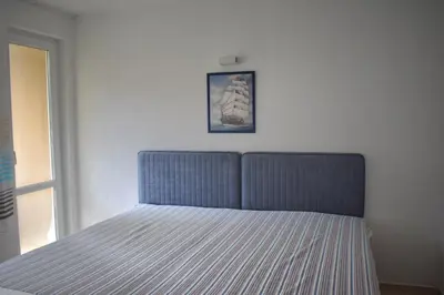 a bed in a bedroom with a picture on the wall at Вlue horizon in Sveti Vlas