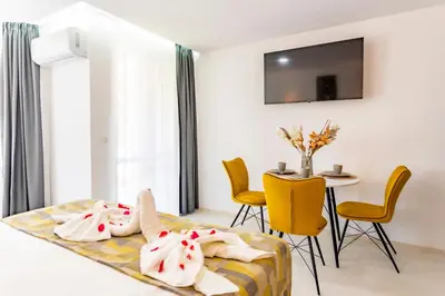 a bedroom with a bed and a table and chairs at J'ADORE Secret Garden A&K Deluxe Studio in Sunny Beach