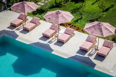 an overhead view of a pool with chairs and umbrellas at J'ADORE Secret Garden A&K Deluxe Studio in Sunny Beach