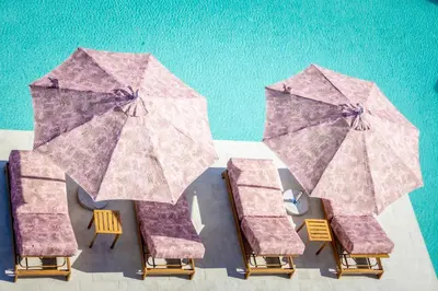 a group of chairs and umbrellas next to a pool at J'ADORE Secret Garden A&K Deluxe Studio in Sunny Beach