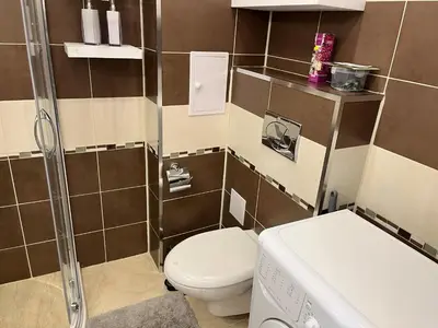 a small bathroom with a toilet and a shower at Сарафово холидейс in Burgas City