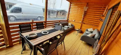 a dining room with a table and chairs and a van at Бунгало Шангри Ла - 1, плаж Градина in Sozopol