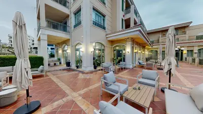 a courtyard in a building with chairs and umbrellas at Flores Garden Pool Side and Sea View Apartment in Chernomorets