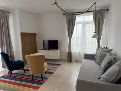 a living room with a couch and a chair at Flores Garden Pool Side and Sea View Apartment in Chernomorets