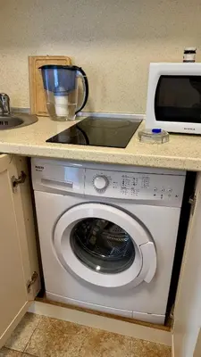 a washing machine in a kitchen with a microwave at Слънчево Море in Nesebar