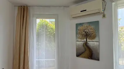 a picture of a tree on a wall next to a window at Слънчево Море in Nesebar
