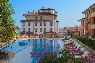 a building with a swimming pool in front of a building at Przytulny apartament w Sweti Vlas 350m od morza in Burgas City
