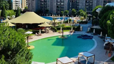 a large swimming pool with chairs and umbrellas at ROYAL BEACH - Private Apartments - Center of Sunny Beach in Sunny Beach