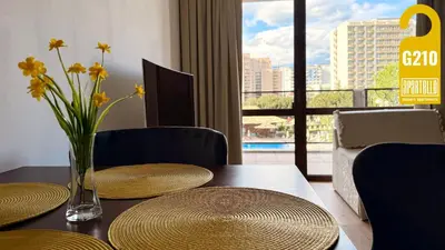a table with two chairs and a vase with flowers on it at ROYAL BEACH - Private Apartments - Center of Sunny Beach in Sunny Beach