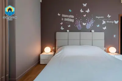 a bedroom with a white bed with butterflies on the wall at Вилла Biala family haven in Byala