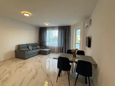 a living room with a couch and a table and chairs at Central Park 7 in Burgas City